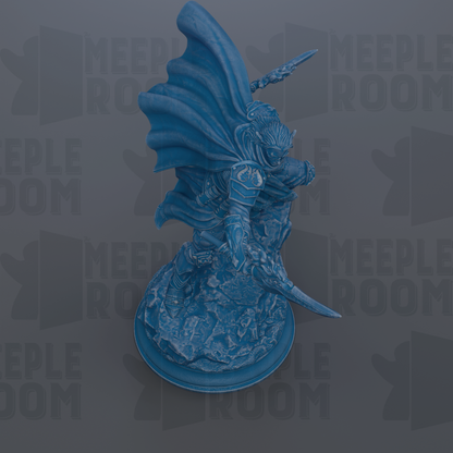 A blue statue of a warrior figure with a flowing cape and sword, standing on a rock formation.