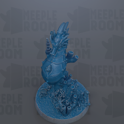 A blue, 3D-rendered dragon figurine is displayed on a circular base, surrounded by various marine elements such as coral and seaweed.