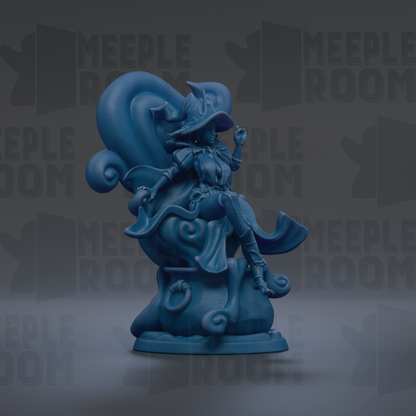 A blue, whimsical figurine of a witch sitting on a chair, with a large, curled hat and flowing robes.