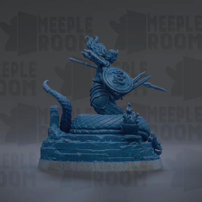 A blue statue of a woman with a shield and sword, sitting on a rock formation.