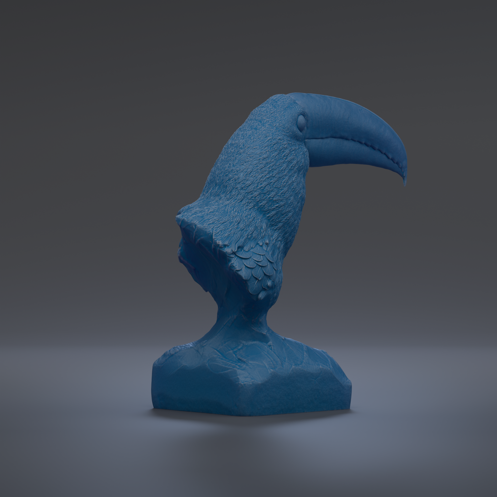A blue bird sculpture is displayed on a gray surface.