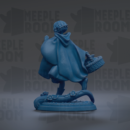 A blue figurine of a person wearing a cape and carrying a basket, standing on a platform with flowers.