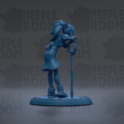A blue figurine of a person standing on a platform, holding a cane.