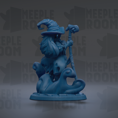 A blue figurine of a wizard or magical being, possibly a gnome or wizard, holding a staff and standing on a rock or pedestal.