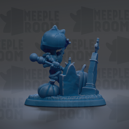 A blue figurine of a character with a bow stands on a pedestal, surrounded by a graveyard-like setting with tombstones and a gravestone.