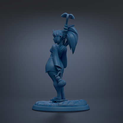 A blue figurine of a person standing on a platform, holding a small object in their hand.
