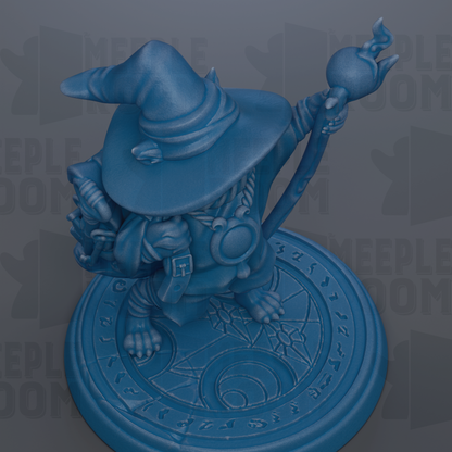 A blue figurine of a wizard or magical character, wearing a pointed hat and holding a staff, is depicted on a circular base with a patterned design.