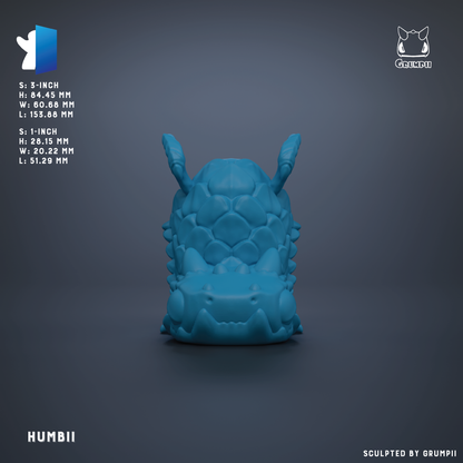 The image is a 3D rendering of a blue, sculpted object with a textured, organic appearance. The object is described as a "HUMBI" and is shown in a close-up view against a dark background.