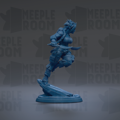 A blue figurine of a female character, possibly a warrior or superhero, is depicted in a dynamic pose, standing on a platform and holding a weapon.