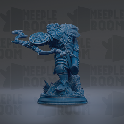 A blue figurine of a warrior standing on a rock, holding a shield and sword.