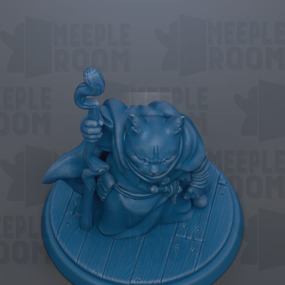 A blue figurine of a cat holding a staff and standing on a wooden base.