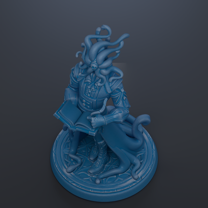 A blue figurine of a fantastical creature with an intricate, flowing design and a book in its hands, sitting on a circular base.