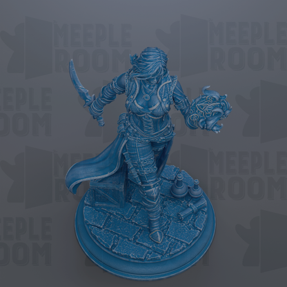 A blue figurine of a woman holding a sword and a headdress, standing on a pedestal.