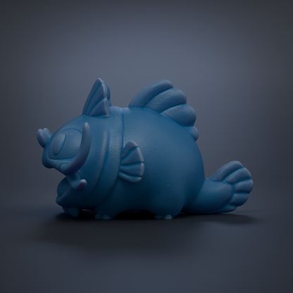 A blue, cartoonish fish figurine is sitting on a dark surface.