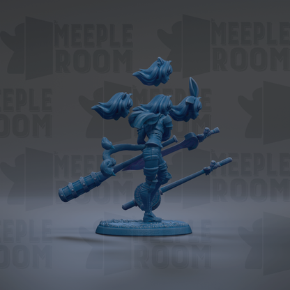 A blue figurine of a female character with flowing hair and a sword, standing on a base and holding a staff.