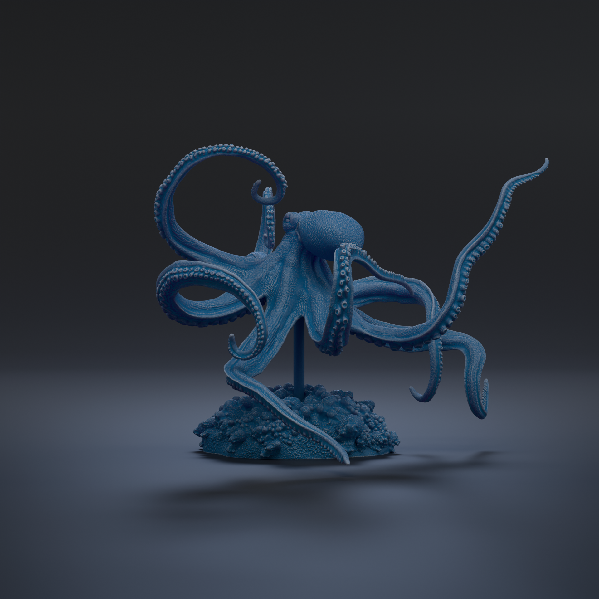A blue, 3D-rendered octopus figurine is displayed on a base, with its tentacles spread out against a dark background.