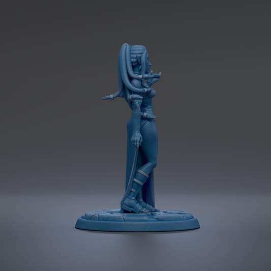A blue figurine of a woman with long hair and a snake-like design on her back, standing on a base.