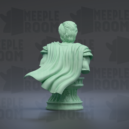 A green statue of a person sitting on a pedestal, with a flowing cape draped over their shoulders.