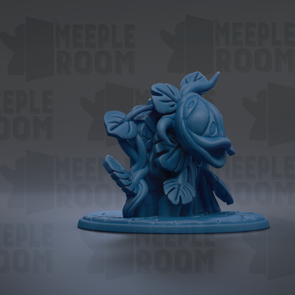 A blue, cartoonish figurine of a flower or plant with large leaves, sitting on a circular base.