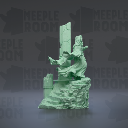 A green, sculpted statue of a figure standing on a rocky outcrop, with a flowing robe and a long headdress.