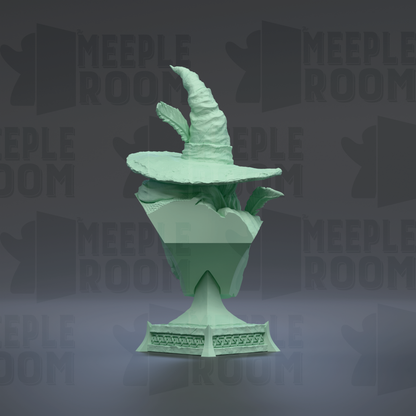 A green, 3D-rendered wizard's hat sits atop a green, 3D-rendered trophy or trophy base, both set against a dark background with repeated text.