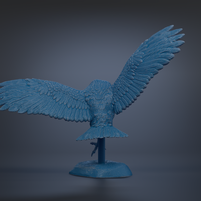 A blue bird sculpture with outstretched wings is displayed on a blue base against a dark background.