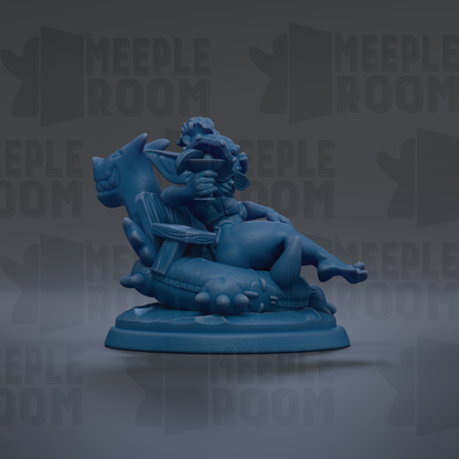 A blue figurine of a person sitting on a chair, with a dragon-like creature on their lap.