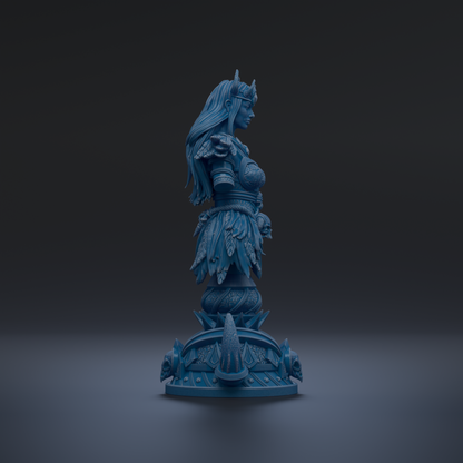 A blue statue of a woman with long hair and a crown, standing on a pedestal with intricate designs.