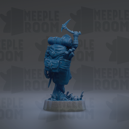 A blue figurine of a person holding a walking stick and a backpack, standing on a base with a plant-like structure.