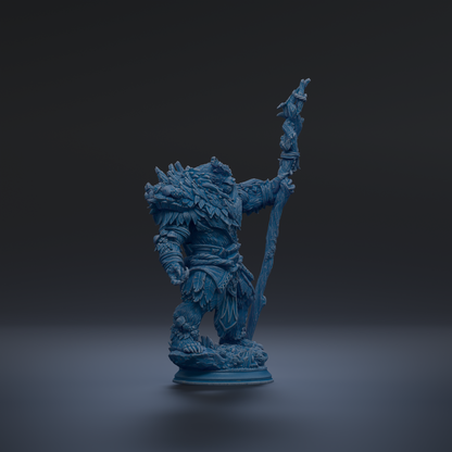 A blue figurine of a fantastical creature, possibly a dragon or serpent, standing on a pedestal and holding a staff or staff-like object.