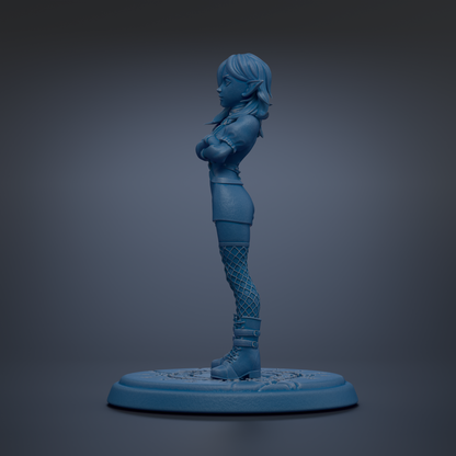 A blue figurine of a person standing with arms crossed, wearing a skirt and boots, on a blue base.