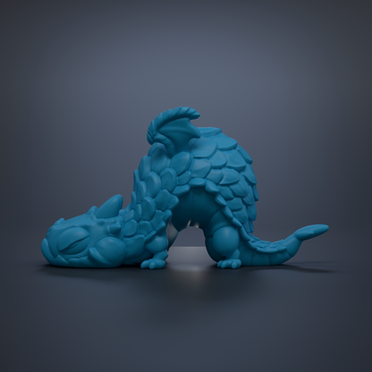 A blue, 3D-rendered dragon figurine is depicted in a resting position against a dark background.
