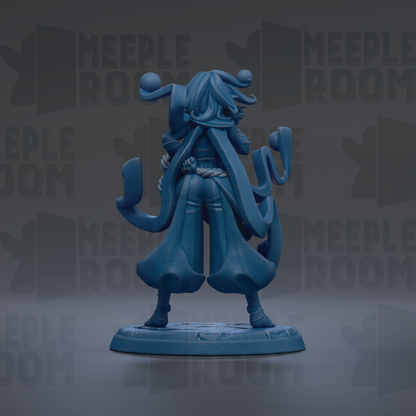 A blue figurine of a person with long hair and a flowing robe, standing on a base and facing away from the camera.