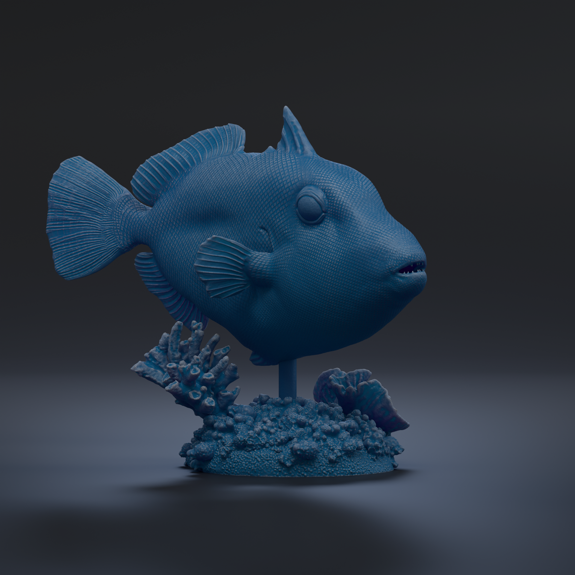 A 3D rendering of a blue fish sculpture, with its fins and tail visible, sitting on a base with coral and other marine life.