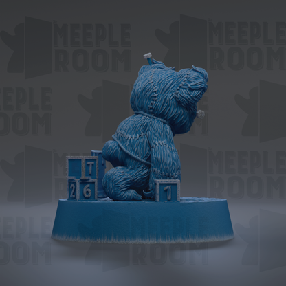 A blue bear figurine sitting on a blue base with blocks displaying numbers.