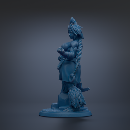 A blue figurine of a woman with long braided hair and a crown-like headdress, standing on a base and holding a weapon.