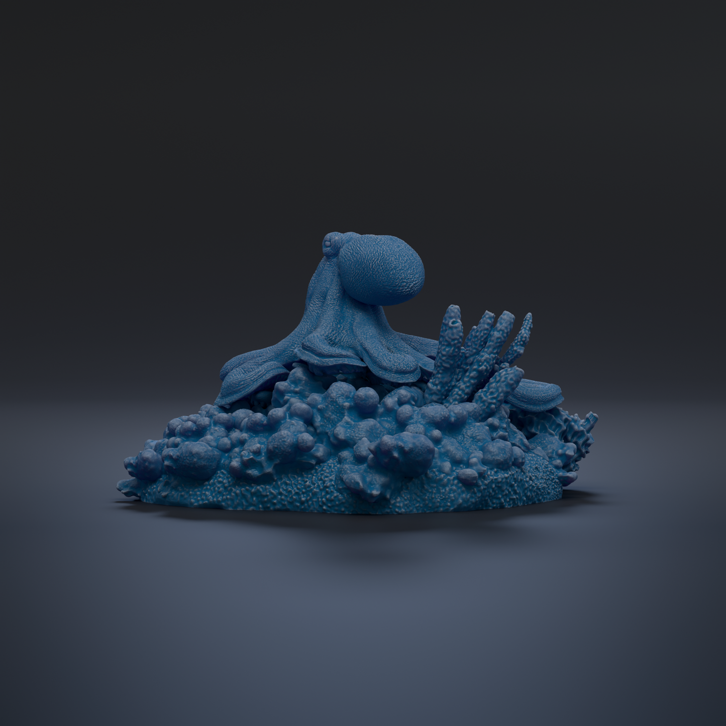 A blue octopus sculpture is displayed on a pile of blue and white textured objects against a dark background.