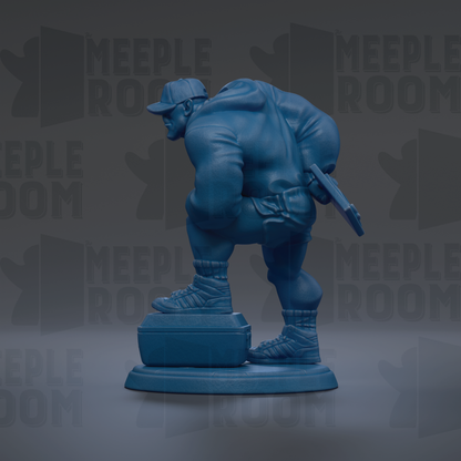 A blue statue of a person holding a gun and standing on a suitcase.
