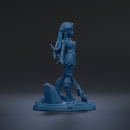 A blue figurine of a female character with long hair and a sword, standing on a rock formation against a dark background.