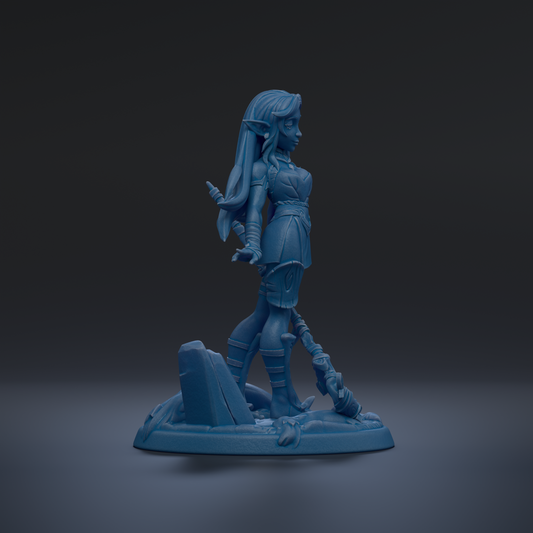 A blue figurine of a female character with long hair and a sword, standing on a rock formation against a dark background.
